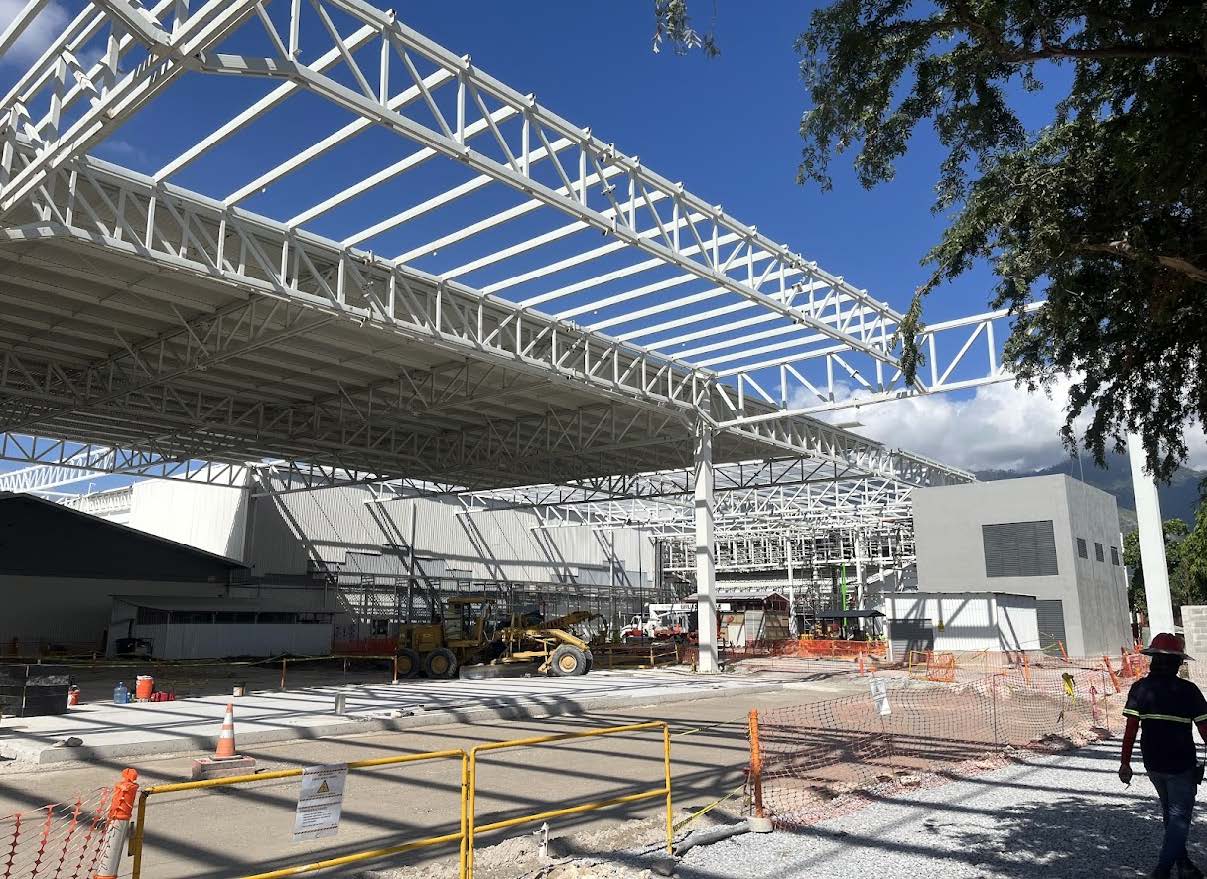 Montaje de estructura metálica de nave industrial con columnas y cerchas expuestas.