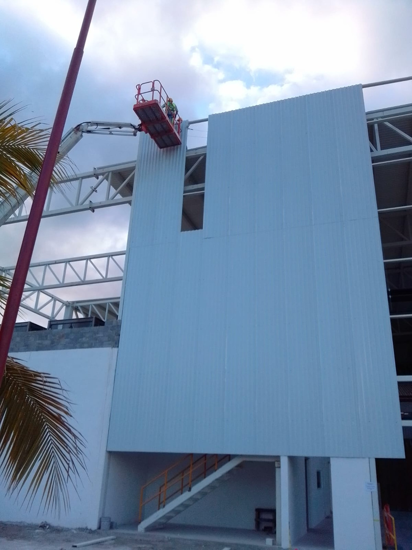 Instalación de paneles metálicos de cerramiento con plataforma elevadora.