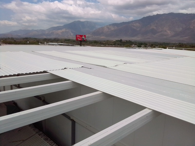 Instalación de lámina de techo sobre estructura metálica industrial.