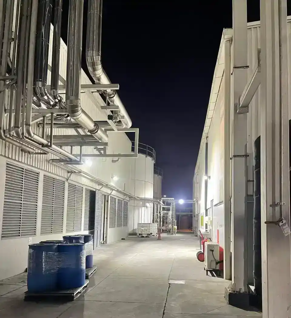 Iluminación instalada en un corredor técnico con tuberías industriales