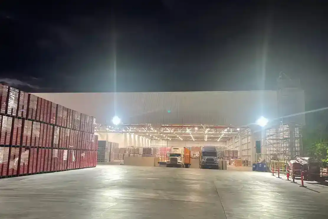 Área exterior de carga y movimiento de vehículos iluminada durante la noche