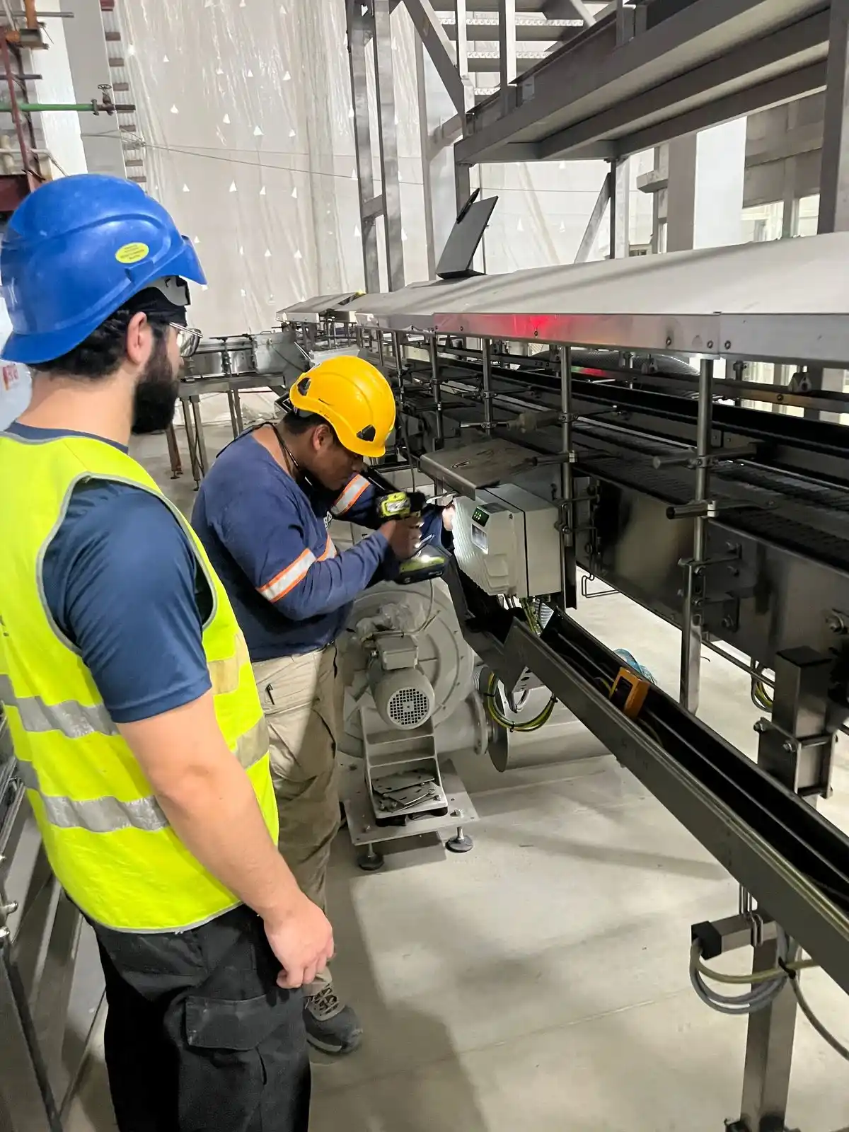 Personal técnico trabajando en la integración eléctrica de maquinaria Krones