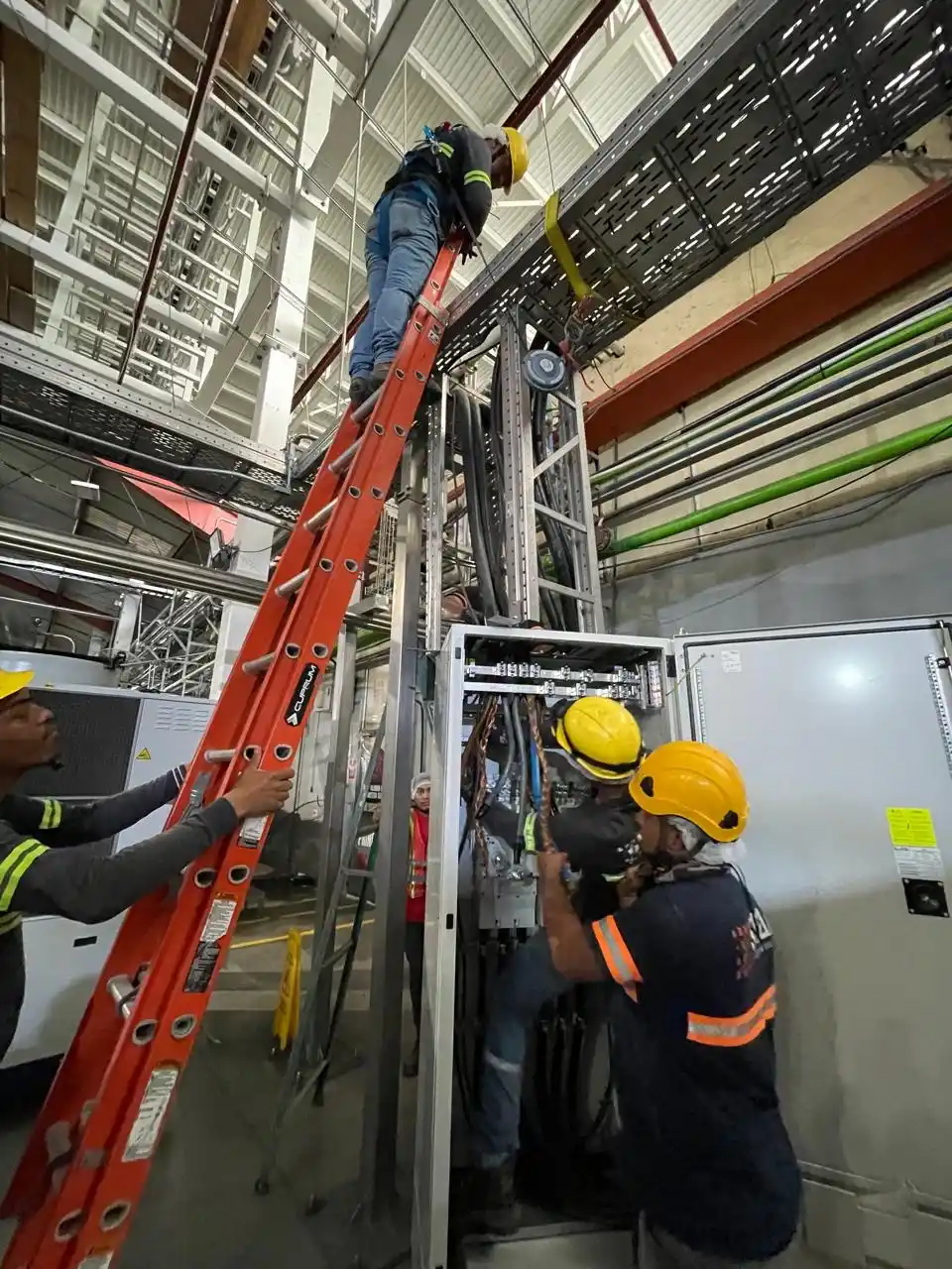 Técnicos conectando cableado de potencia en un gabinete de distribución