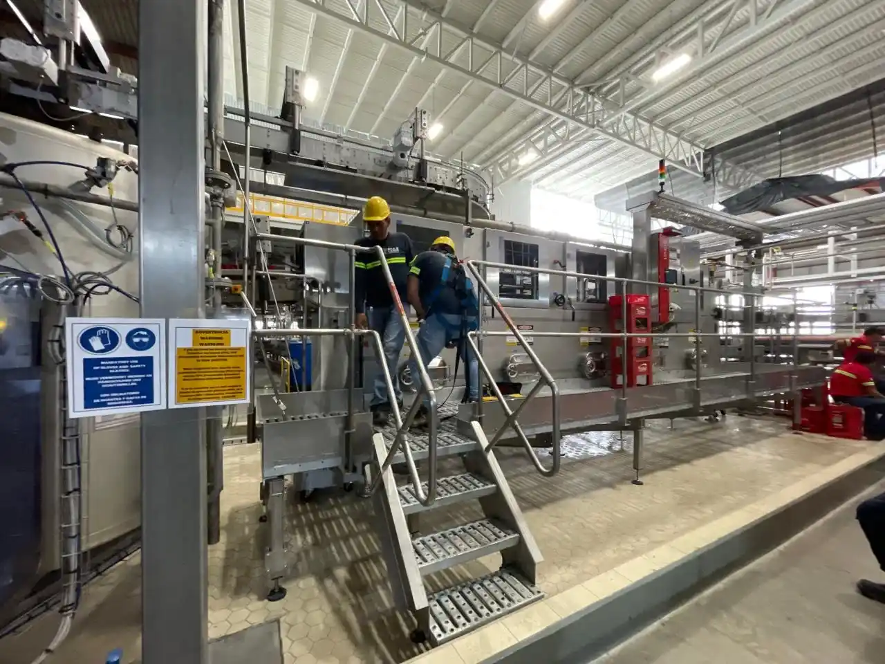 Personal técnico trabajando en maquinaria del área húmeda de la línea Krones