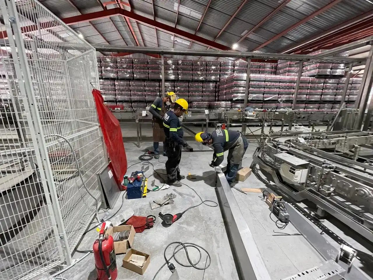 Personal técnico trabajando en la instalación eléctrica de maquinaria Krones