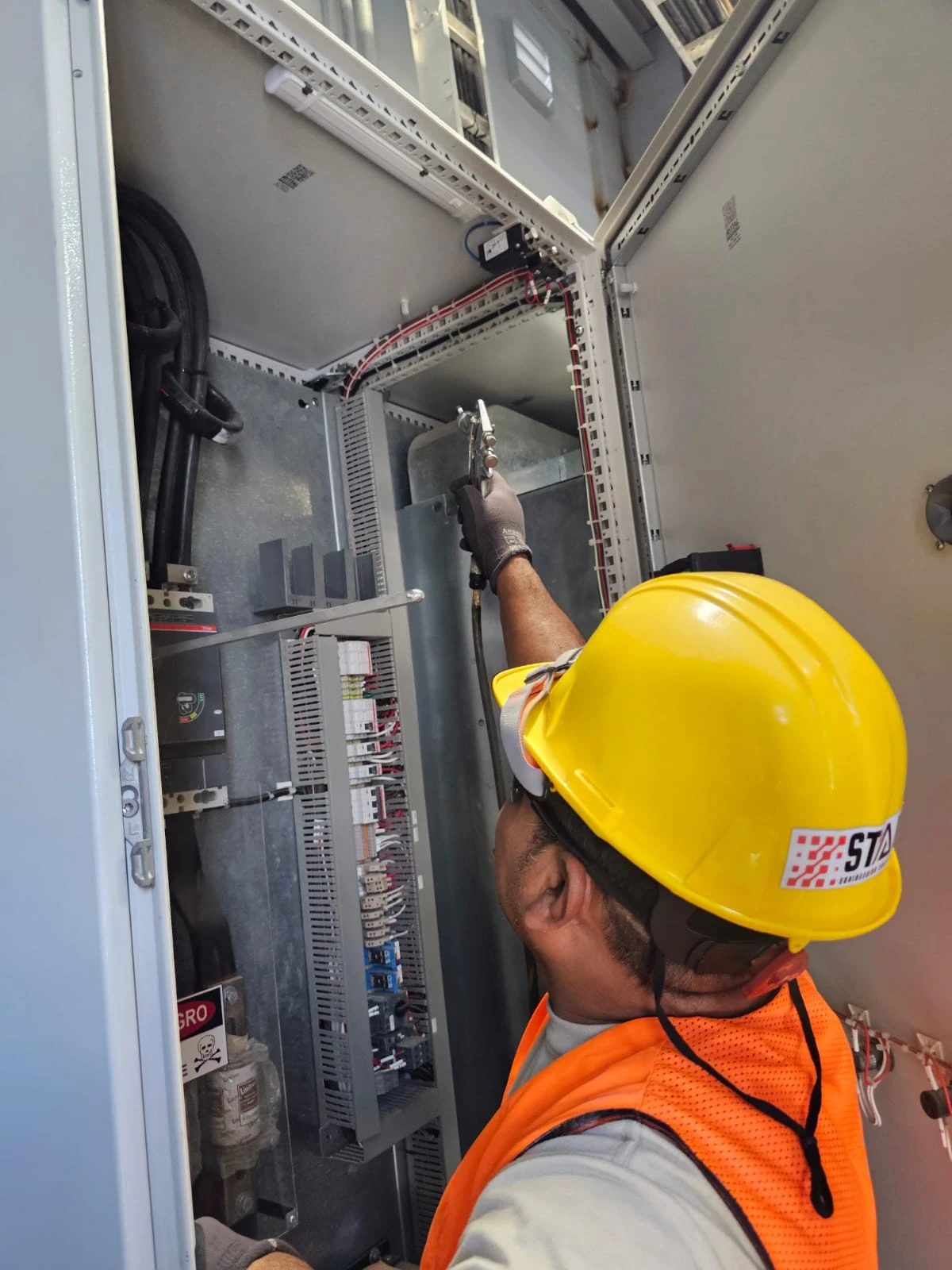 Técnico realizando ajustes dentro de un gabinete eléctrico