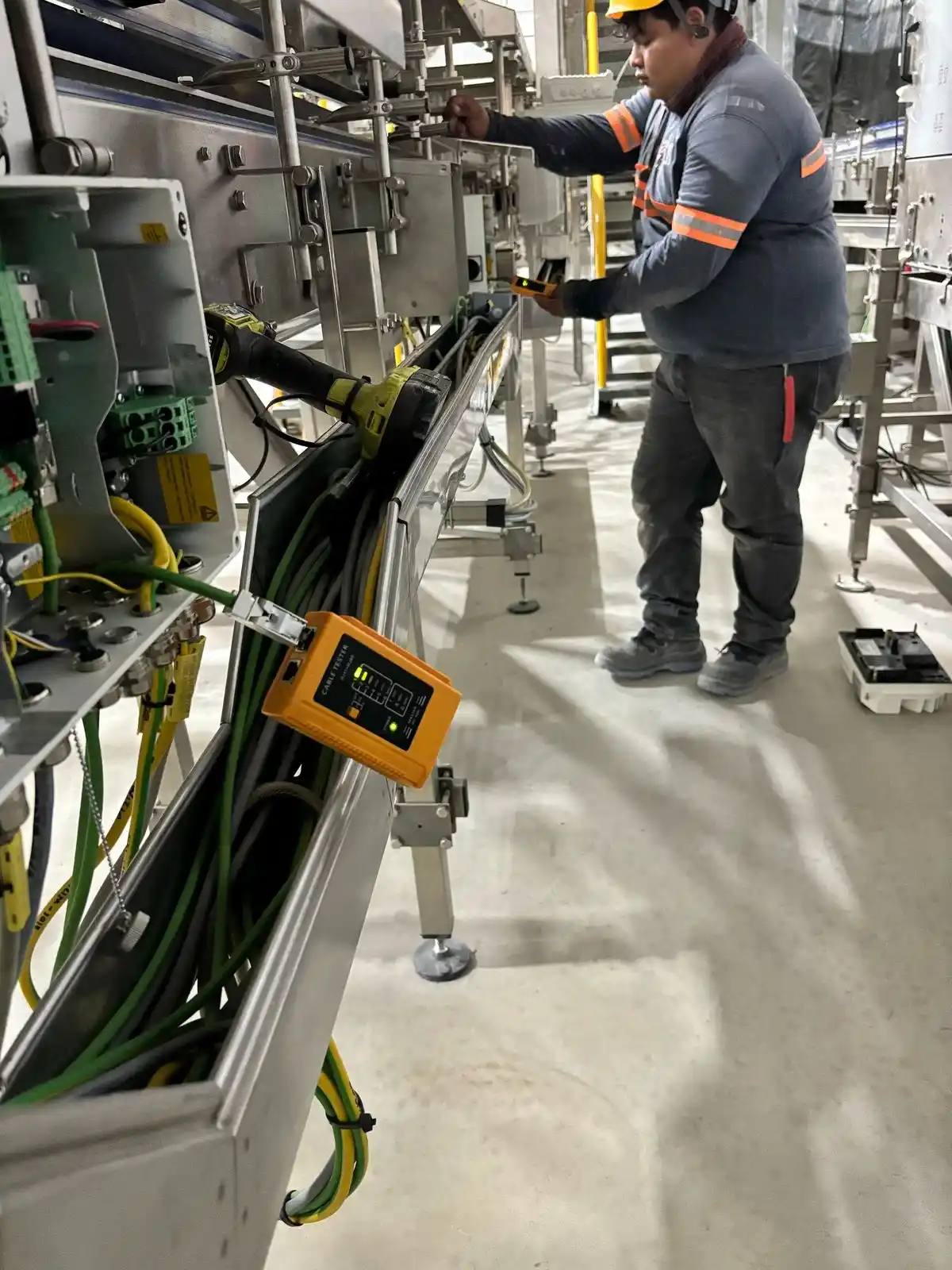 Técnico verificando el cableado eléctrico de una línea industrial de lata Krones
