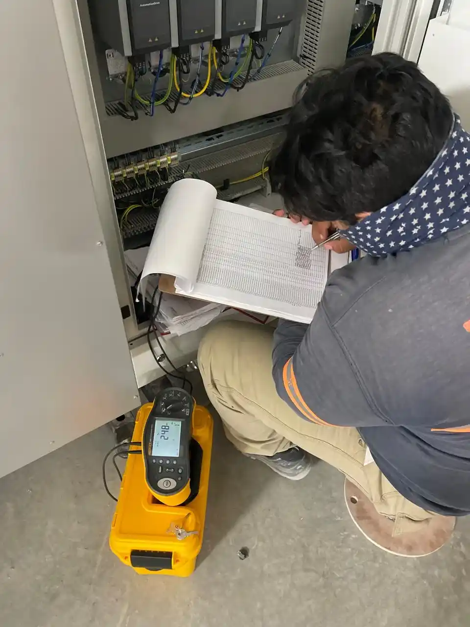 Técnico inspeccionando componentes eléctricos de una línea de producción
