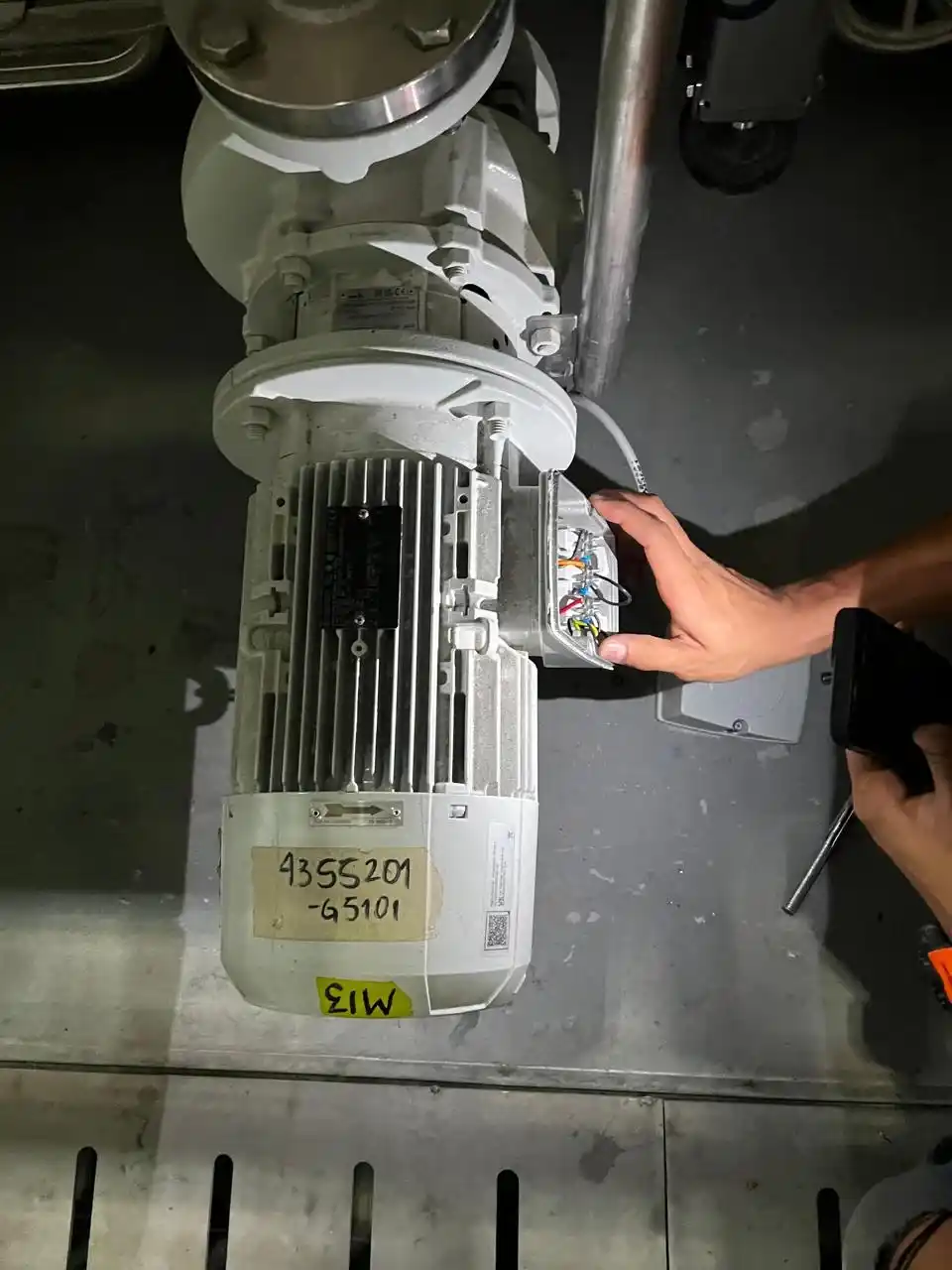 Técnico realizando ajustes en componentes de una línea industrial