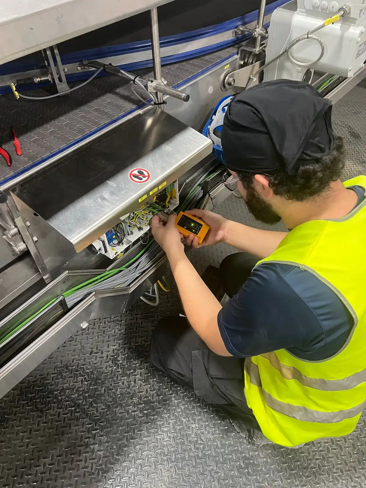 Técnico realizando mediciones eléctricas en maquinaria de producción